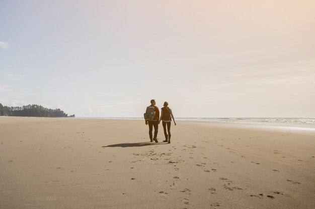 Paar hand in hand en wandelen op het strand