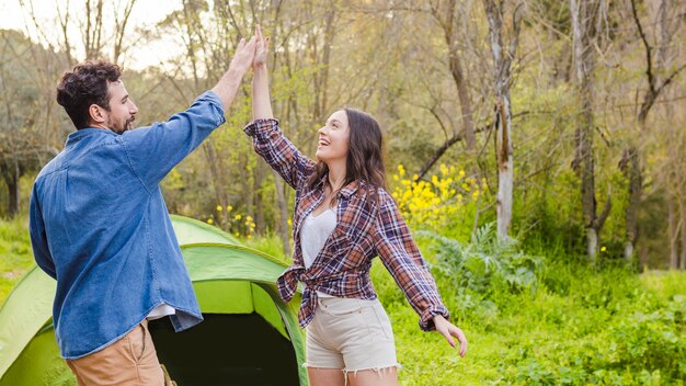 Paar high-fiving in de buurt van tent