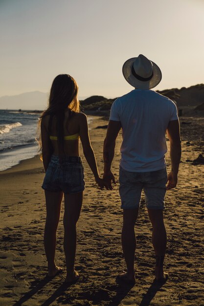 Paar houden handen op het strand