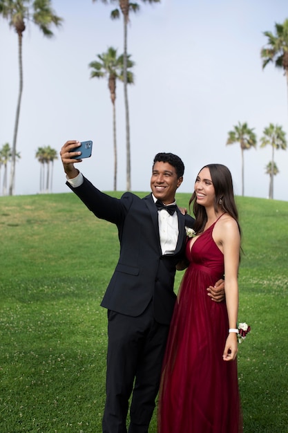 Paar in afstudeerbalkleding die een selfie maakt