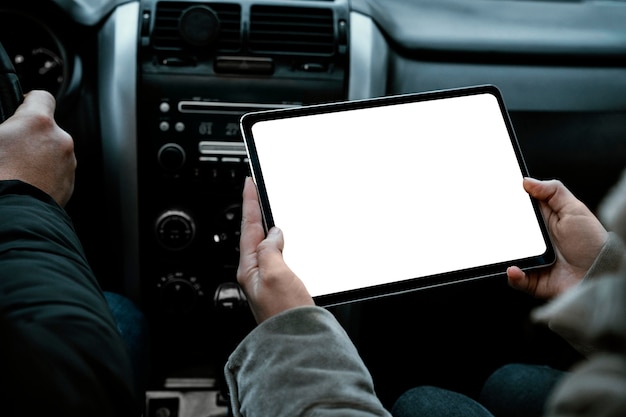 Paar in de auto die tablet raadplegen tijdens een roadtrip