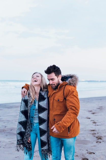 Paar in warme kleren op strand