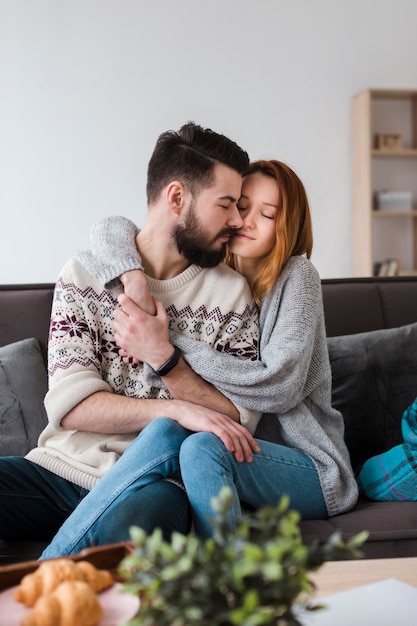 Paar in woonkamer knuffelen vooraanzicht