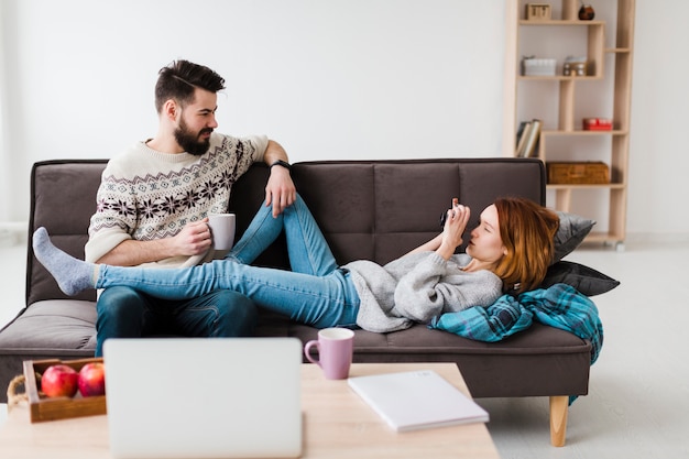 Paar in woonkamer koffie drinken