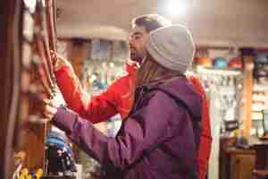 Gratis foto paar kijken naar skistok in een winkel