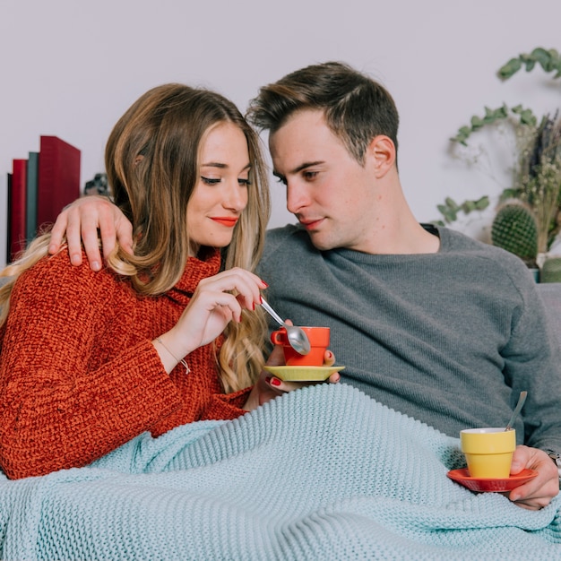 Paar knuffelen en het drinken van warme dranken