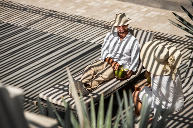 Paar kokosmelk drinken bij het zwembad tijdens vakantie