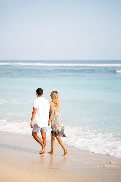 Paar lopen op het strand op vakantie