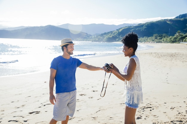 Gratis foto paar met camera op het strand