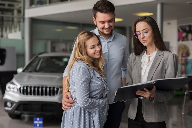 Gratis foto paar praten met een autodealer