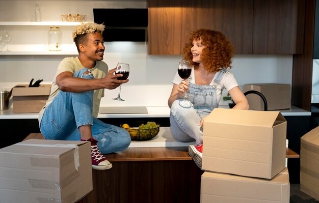 Paar samen wijn drinken in de keuken van hun nieuwe huis