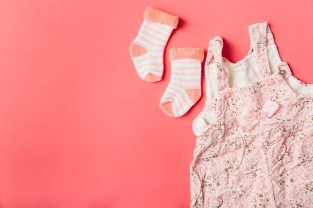 Paar sok en babykleding op felgekleurde achtergrond