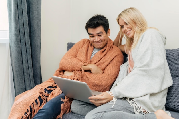 Paar thuis samen met behulp van laptop op de Bank