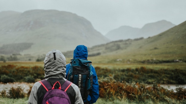 Paar trekking door de regen in de Hooglanden