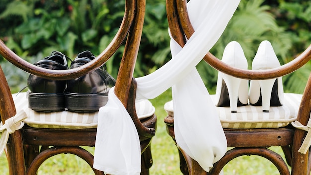 Paar trouwschoenen op houten stoel in het park
