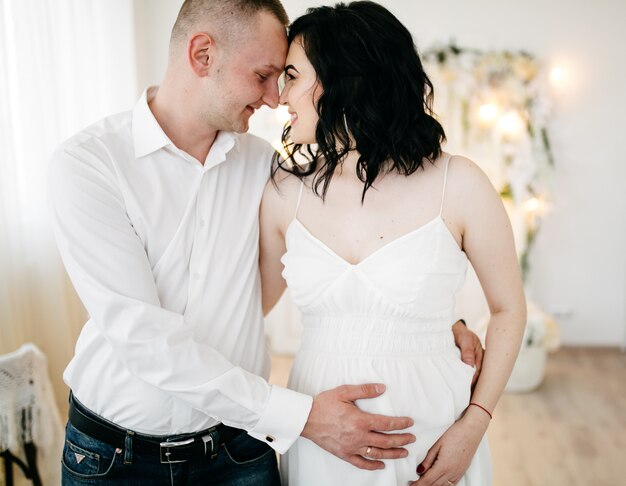 Paar van knappe echtgenoot en het mooie pragnant vrouw stellen bij studio