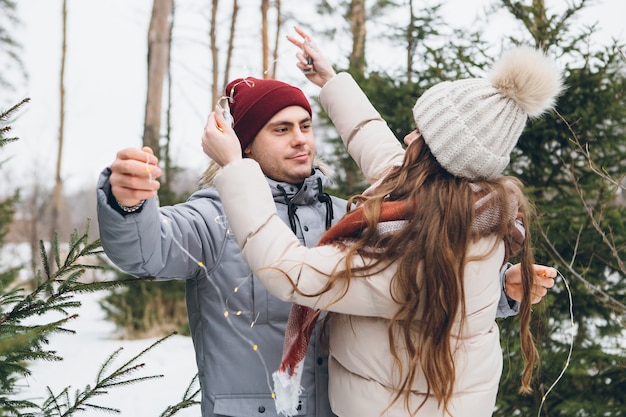 Paar verliefd knuffels en kusjes in een winter naaldbos Premium Foto