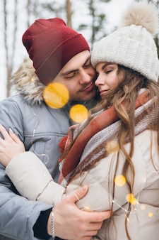 Paar verliefd knuffels en kusjes in een winter naaldbos