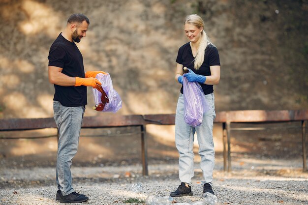 Paar verzamelt afval in vuilniszakken in park