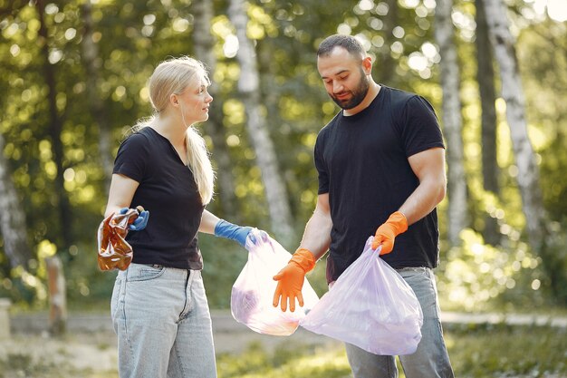 Paar verzamelt afval in vuilniszakken in park