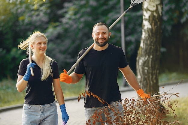 Paar verzamelt bladeren en maakt het park schoon