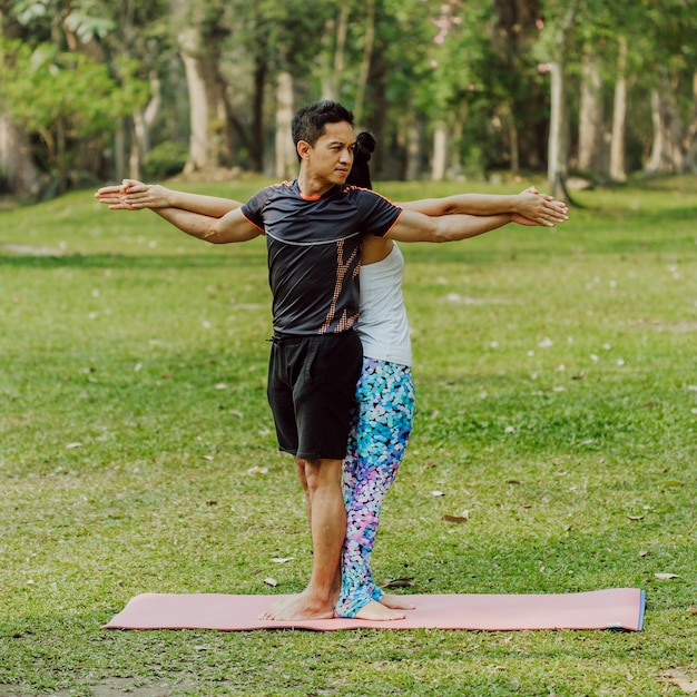 Paar, yoga, gras en bomen