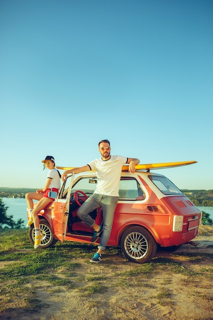 Paar zitten en rusten op het strand op een zomerdag in de buurt van de rivier. Liefde, gelukkige familie, vakantie, reizen, zomerconcept.