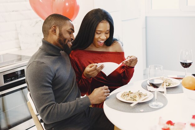 Paar zittend aan tafel, eten, praten en lachen op Valentijnsdag