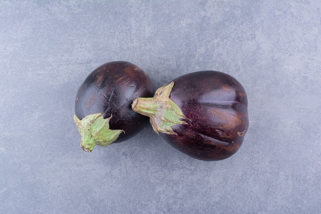 Paarse aubergines geïsoleerd op blauwe ondergrond