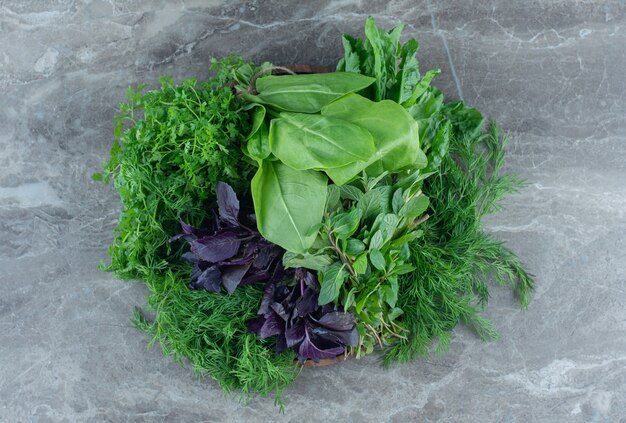 Paarse basilicum en met peterselie, op de marmeren tafel.