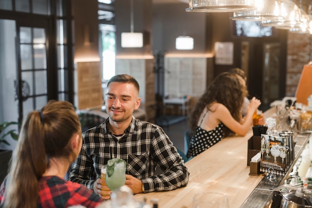 Paarzitting in bar die van dranken genieten bij bar