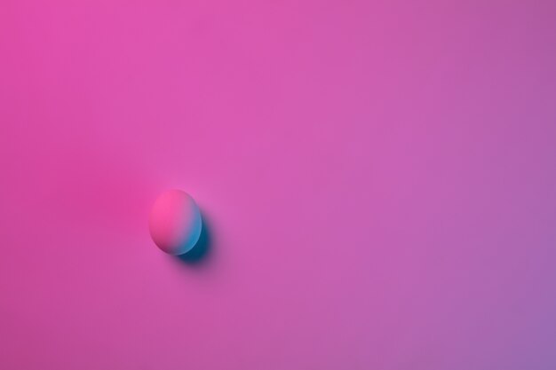 Paastradities, roze-blauw gekleurde eieren op roze achtergrond, neonlicht