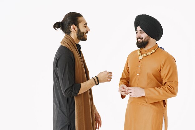 Pakistaanse man en Indiase mannen in traditionele kleding. De vrienden praten op een witte achtergrond, geïsoleerd. Agremment tussen landen.