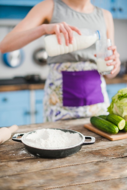 Gratis foto pan met bloem dichtbij vrouwen gietende melk