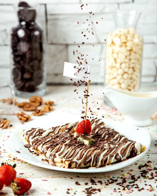 Pannenkoek bedekt met chocoladesiroop en besprenkeld met geraspte pistachenoten