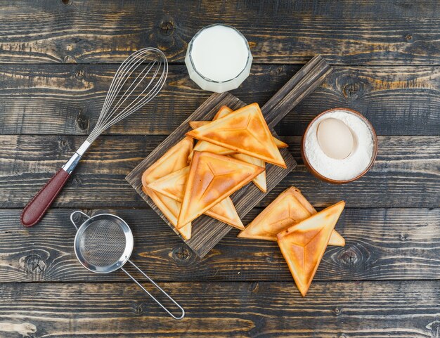 Pannenkoek op een houten bord met ingrediënten en gereedschappen