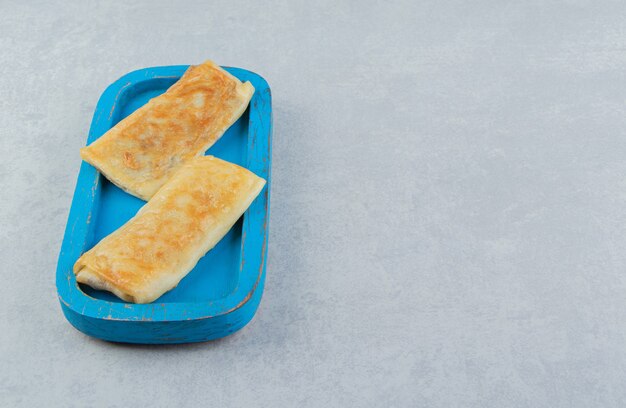 Pannenkoeken gevuld met vlees op blauw bord.