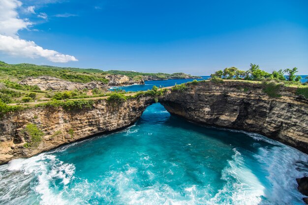 Panorama van gebroken strand in Nusa Penida, Bali, Indonesië. Blauwe lucht, turquoise water.