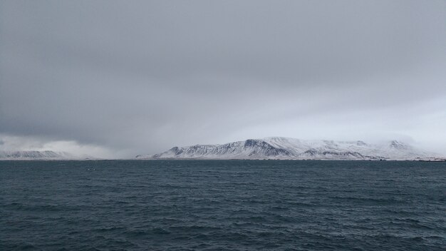Panoramische opname van een besneeuwde bergkust op een bewolkte dag