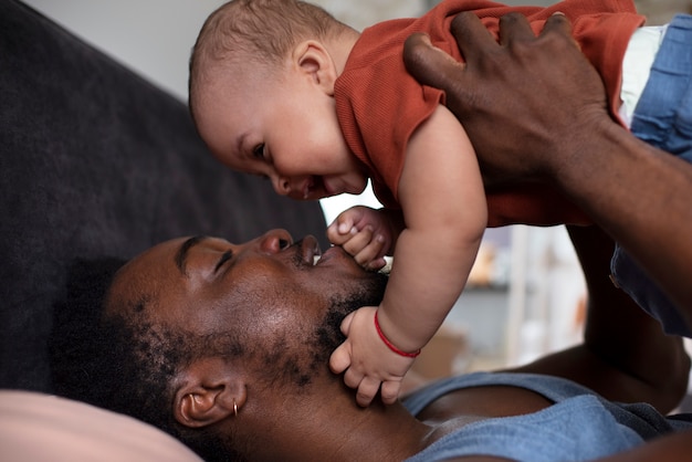 Gratis foto papa brengt tijd door met zijn zwarte baby