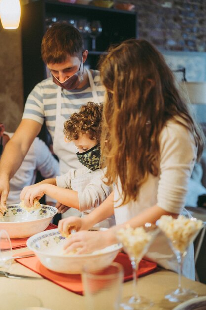 Papa en kinderen koken pasta tijdens een masterclass gastronomie