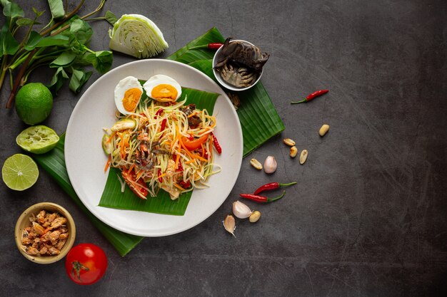 Papajasalade geserveerd met rijstnoedels en groentesalade Versierd met Thaise voedselingrediënten.