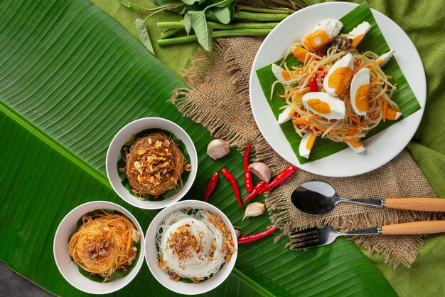Papajasalade geserveerd met rijstnoedels en groentesalade Versierd met Thaise voedselingrediënten.