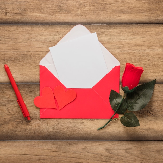 Gratis foto papier in de envelop in de buurt van pen en bloem