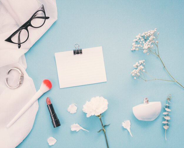 Papier met bloemen en cosmetica op tafel