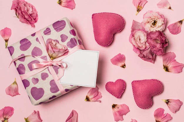 Papier op heden in de buurt van harten, bloemen en bloembladen