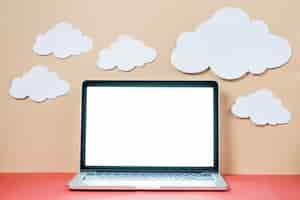 Gratis foto papierwolken over laptop