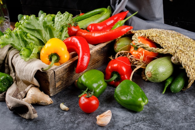 Paprika en groen in de rustieke mand en in een houten dienblad.