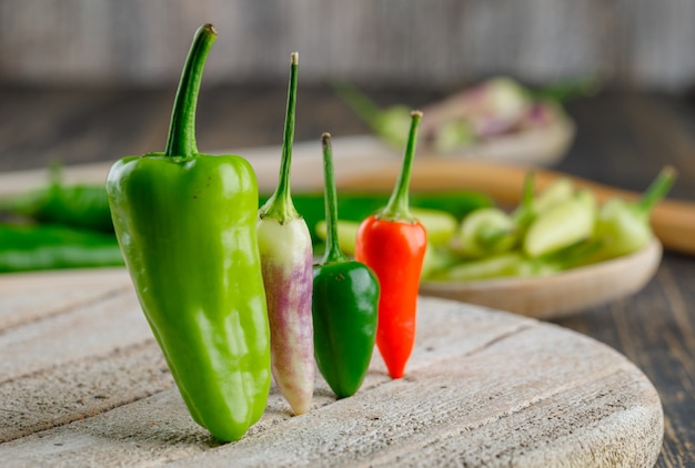 Paprika in houten lepels op houten en snijplank.