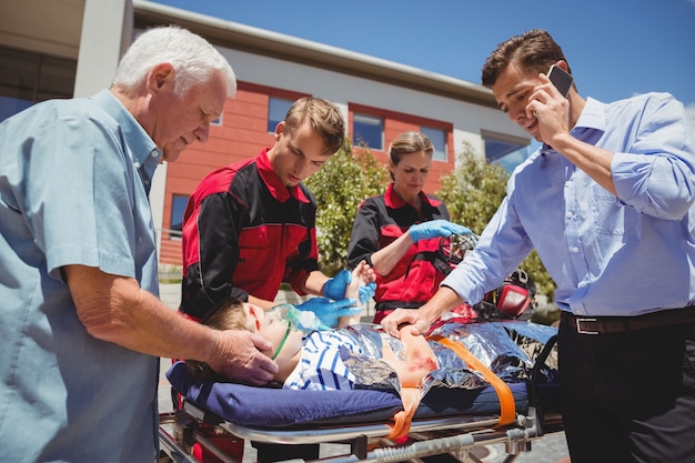 Paramedici die gewonde jongen onderzoeken